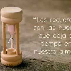 Reloj de arena de madera junto a frases de añoranza: "Los recuerdos son las huellas que deja el tiempo en nuestra alma.