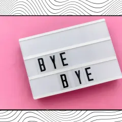 Letrero luminoso con "BYE BYE" sobre fondo rosa, ideal para frases para despedir el año con estilo.