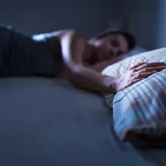 Persona durmiendo, mano sobre almohada. ¿Qué significa soñar con tu padre fallecido?