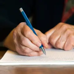 Manos de abuela escribiendo una carta a mi nieto en su cumpleaños.