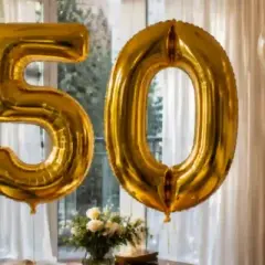 Globos dorados con el número 50, listos para celebrar. ¡Perfectos para encontrar frases divertidas para felicitar 50 cumpleaños!