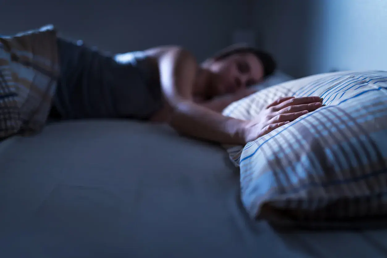 Persona durmiendo, con la mano sobre la almohada. Una imagen que evoca la angustia de soñar que se muere tu padre.